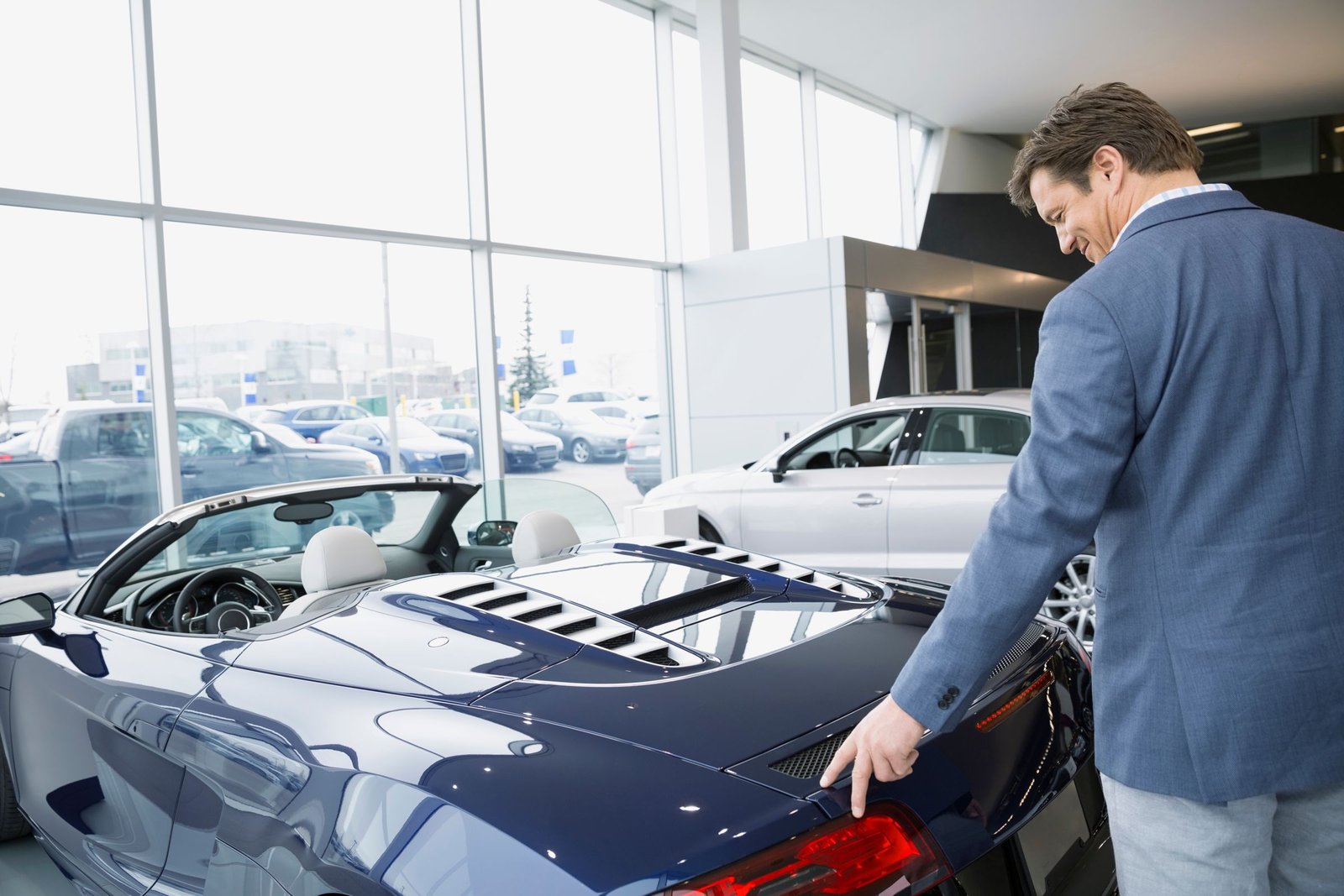 Customer looking at a new convertible in a car showroom