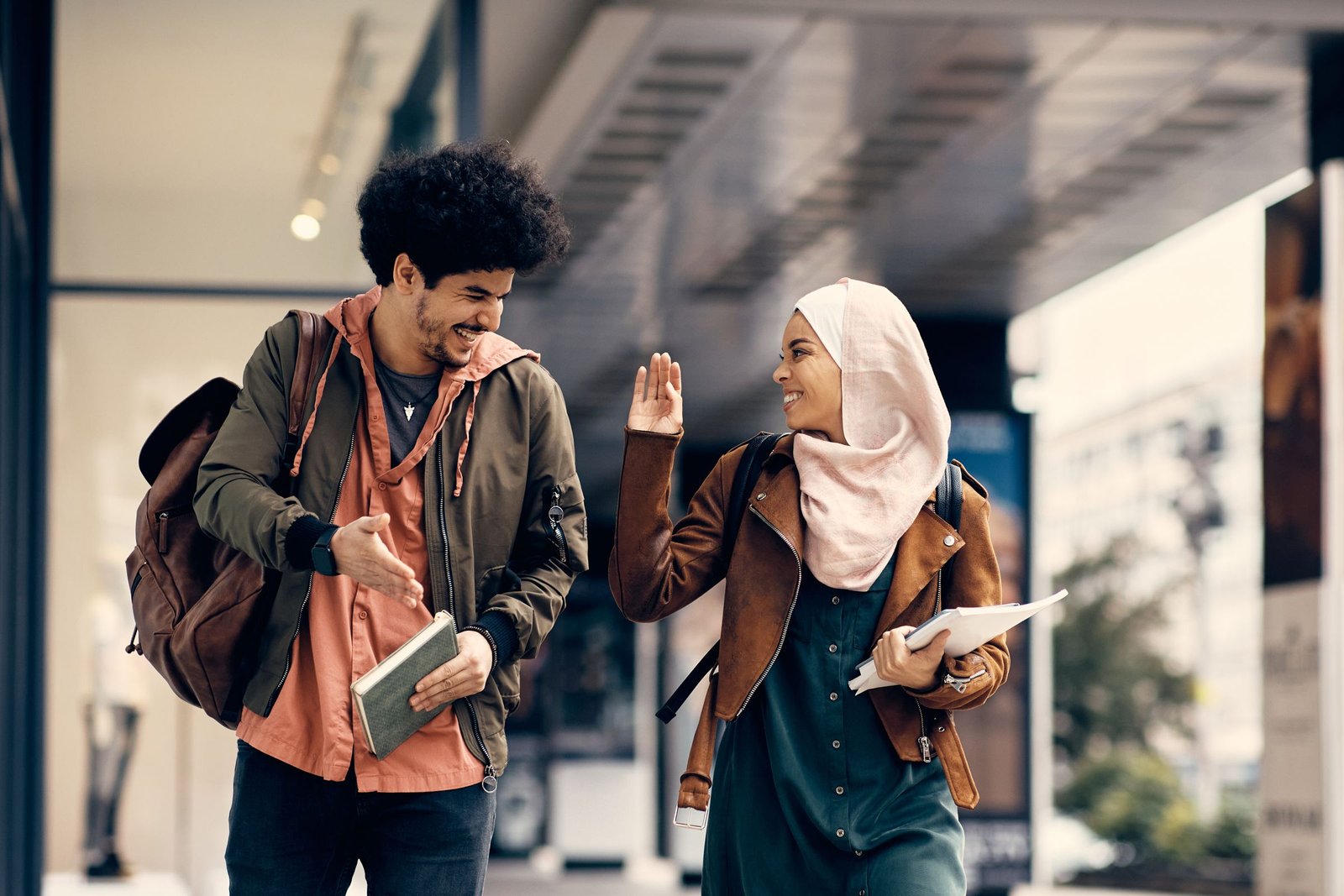 Two students greeting each other on a city campus