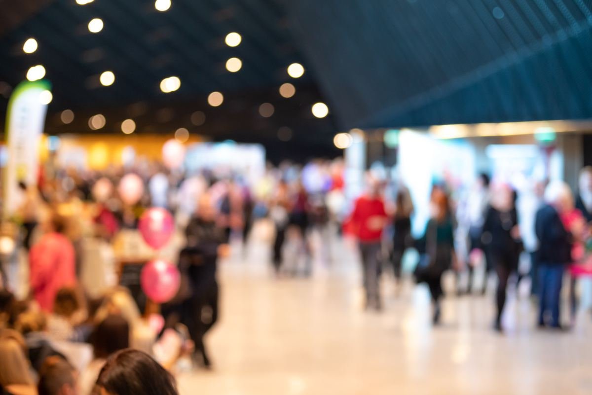 Visitors walking through a busy exhibition hall
