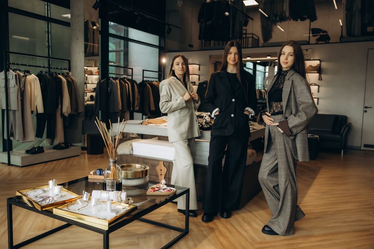 Three women in tailored suits in a fashion boutique